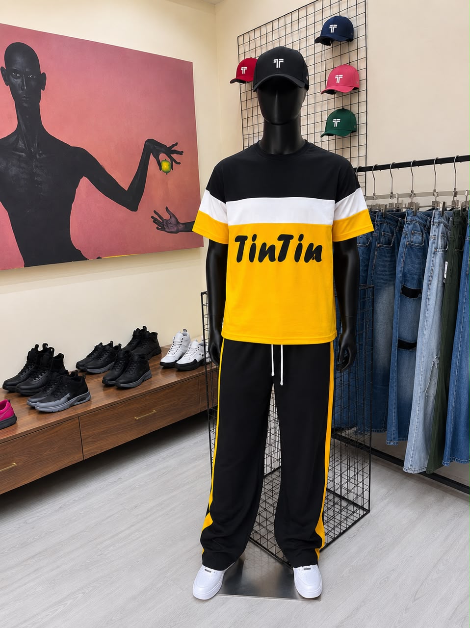 Stylish mannequin displays a vibrant yellow and black outfit with "TinTin" branding, surrounded by footwear and caps.